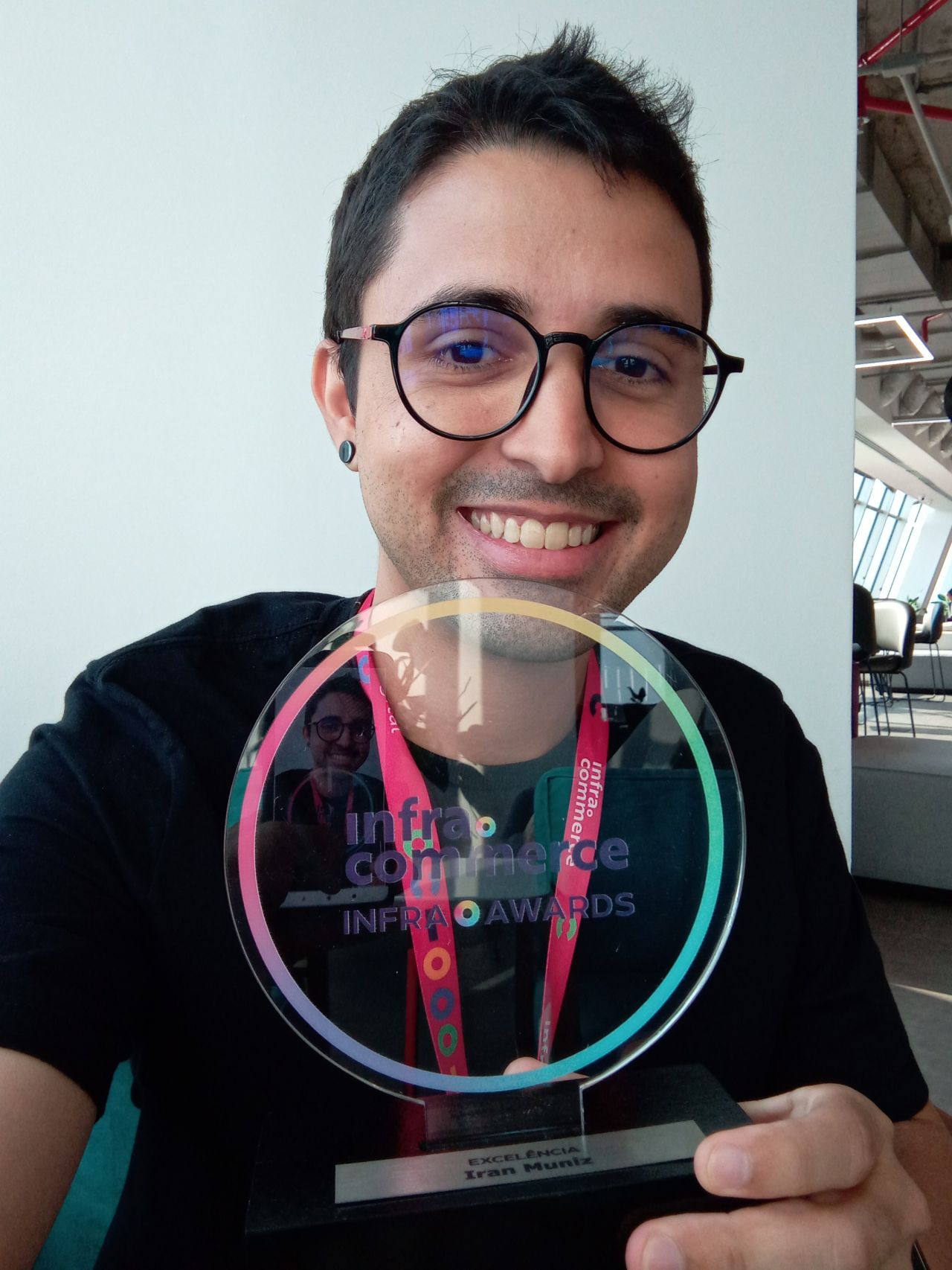 Imagem minha segurando uma premiação na mão esquerda.